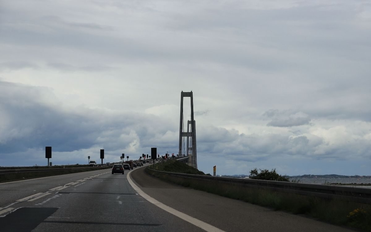 Med bil mot Storebæltsbrons pyloner under en molnig himmel